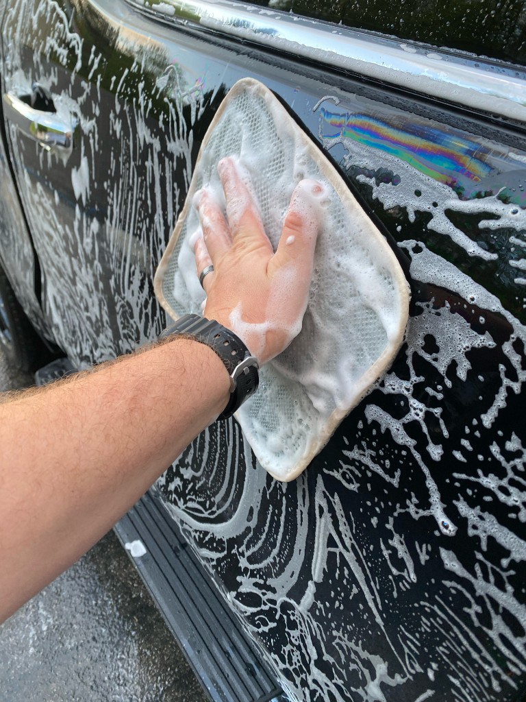Hand washing a black vehicle